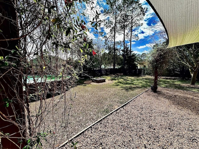 view of yard featuring a fenced backyard and a fire pit