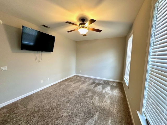 unfurnished bedroom with carpet floors, a ceiling fan, visible vents, and baseboards