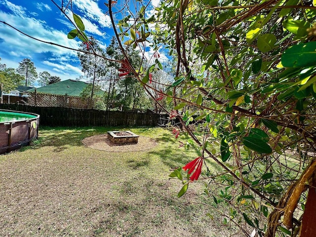 view of yard featuring a fire pit, a fenced backyard, and a fenced in pool