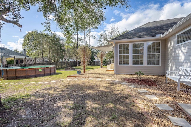 view of yard with fence and an outdoor pool