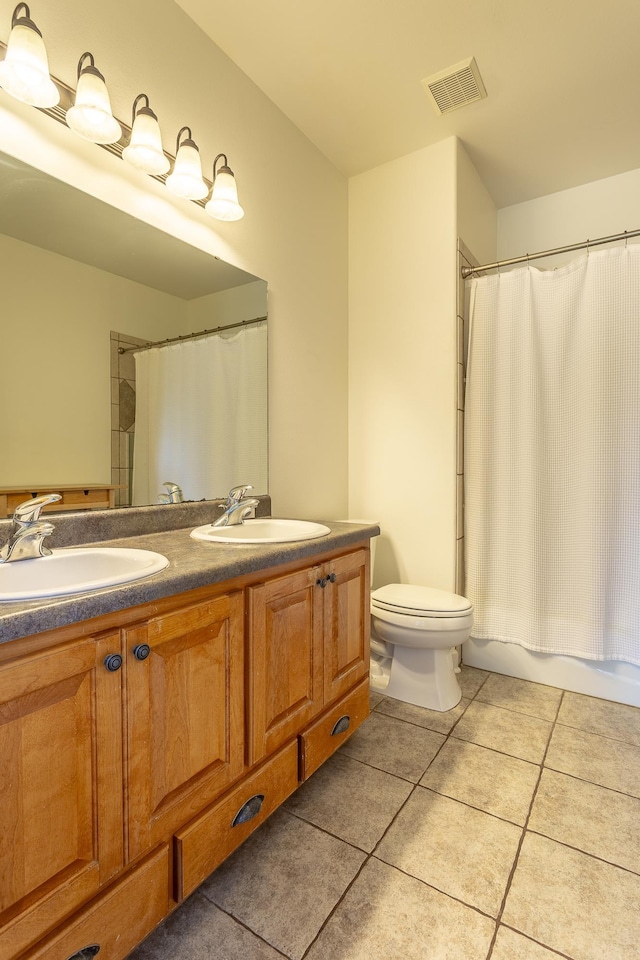 bathroom with double vanity, tile patterned flooring, visible vents, and a sink