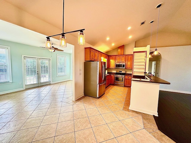 kitchen featuring light tile patterned floors, appliances with stainless steel finishes, dark countertops, and pendant lighting