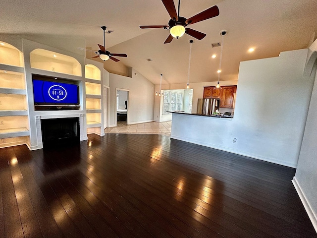 unfurnished living room featuring baseboards, visible vents, light wood-style floors, built in shelves, and a fireplace