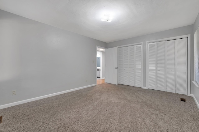 unfurnished bedroom with multiple closets and carpet