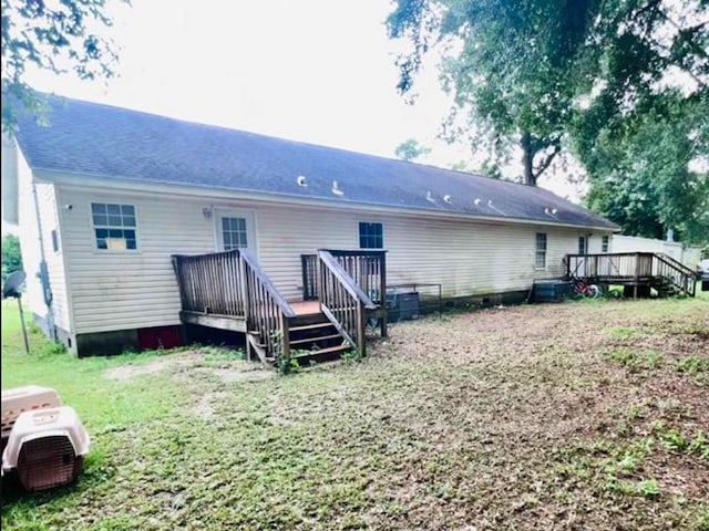 rear view of house with a lawn and a deck