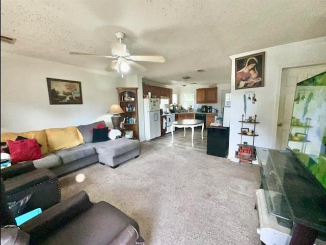 carpeted living room with a textured ceiling and ceiling fan