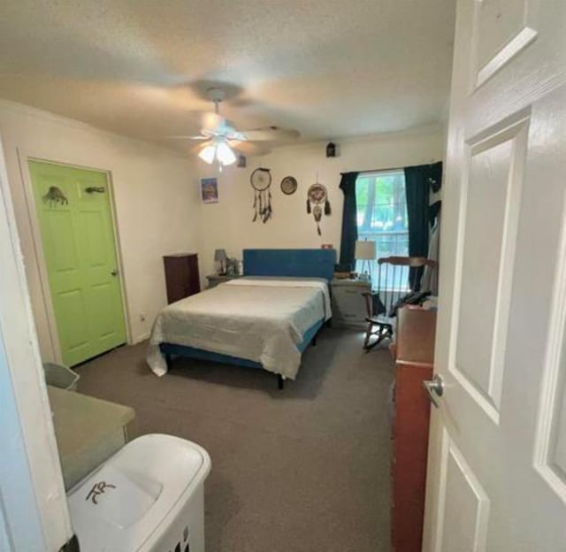 carpeted bedroom with ceiling fan and a textured ceiling