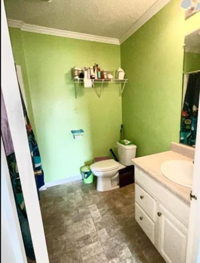 bathroom with a textured ceiling, vanity, toilet, and ornamental molding