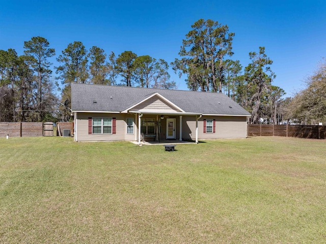 back of property featuring a yard and fence