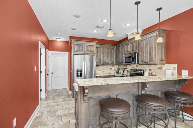 kitchen with decorative backsplash, a peninsula, visible vents, and stainless steel appliances