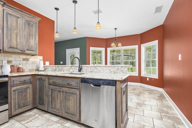 kitchen with visible vents, a peninsula, stainless steel appliances, and a sink