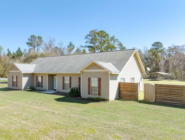 ranch-style home with roof with shingles, a front lawn, and fence