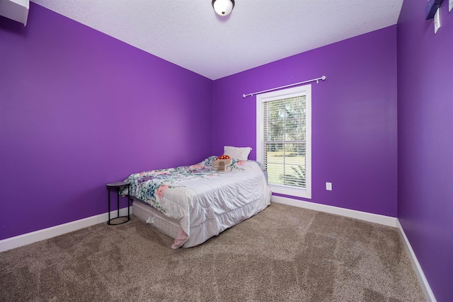 unfurnished bedroom featuring baseboards, carpet, and a textured ceiling