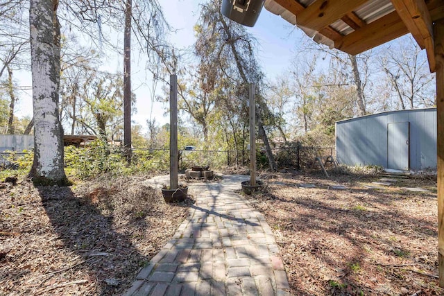 view of yard with an outdoor structure, a storage unit, and a fenced backyard