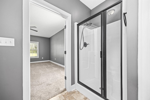 bathroom featuring a shower stall and baseboards