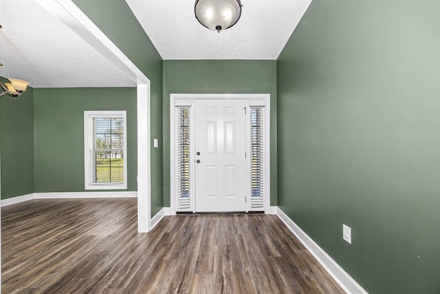 entryway with baseboards, a textured ceiling, and dark wood-style flooring