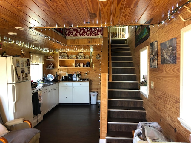 kitchen featuring wood ceiling, wood walls, and white fridge