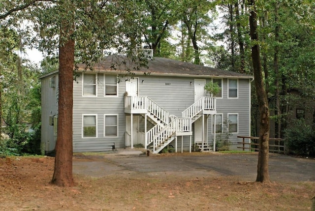 rear view of property featuring stairs