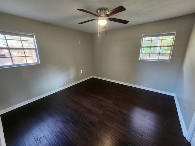 empty room featuring visible vents, dark wood finished floors, baseboards, and ceiling fan