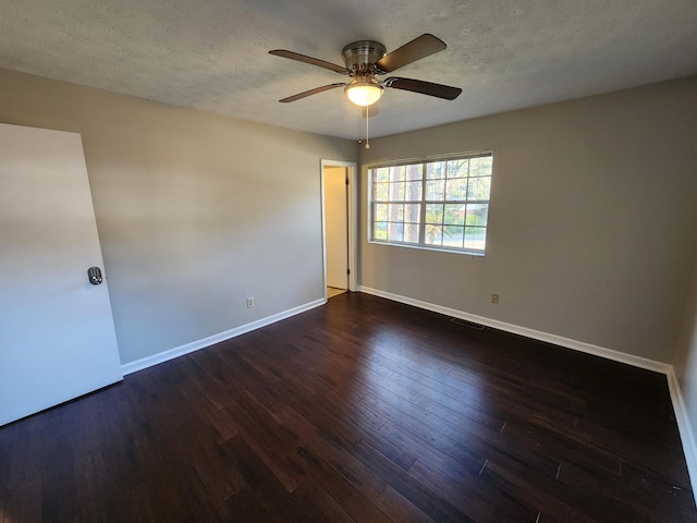 empty room featuring a textured ceiling, wood finished floors, visible vents, and baseboards