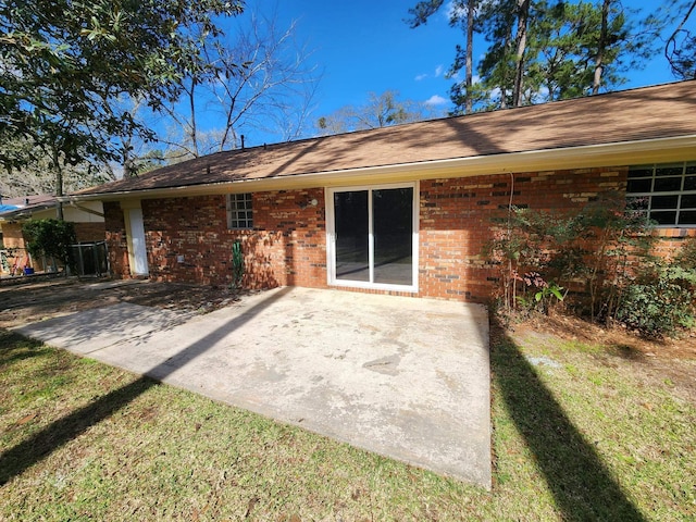 back of property with brick siding and a patio area