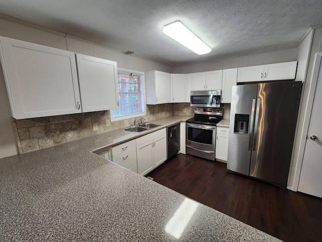 kitchen with dark wood-style floors, backsplash, appliances with stainless steel finishes, white cabinets, and a sink