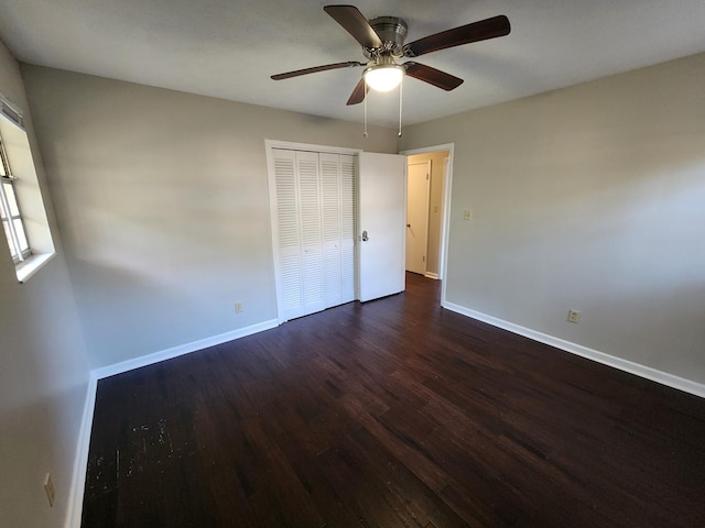 unfurnished bedroom with a ceiling fan, a closet, dark wood finished floors, and baseboards