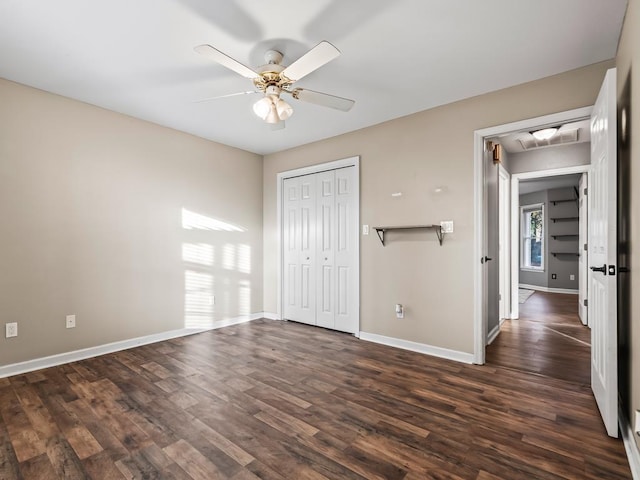 unfurnished bedroom featuring dark wood-type flooring, a closet, and ceiling fan