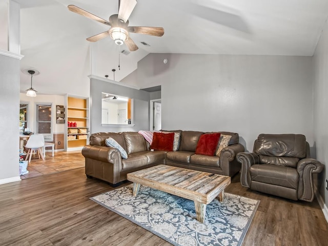 living room featuring dark wood-type flooring, ceiling fan, and vaulted ceiling