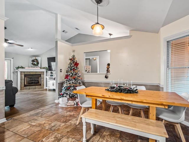 dining room with lofted ceiling, a fireplace, and ceiling fan