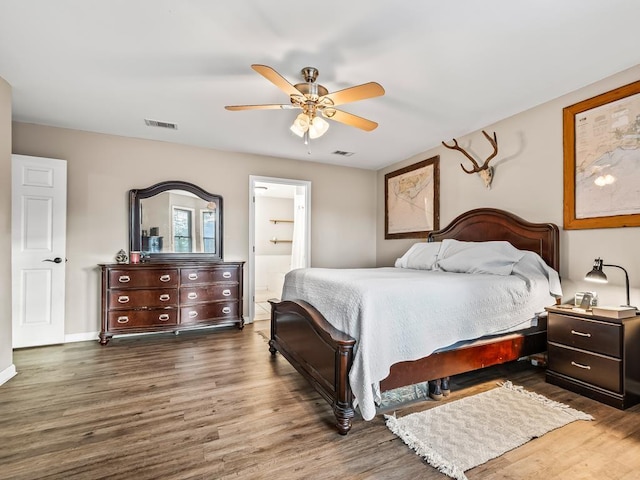 bedroom with dark wood-type flooring, ceiling fan, and ensuite bathroom