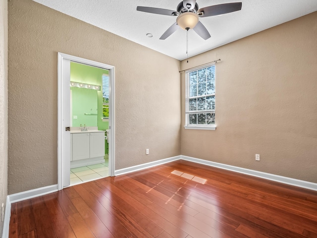 2123 Fernleigh Dr, Tallahassee, FL 32311 - unfurnished room featuring a textured wall, hardwood / wood-style floors, a sink, baseboards, and a ceiling fan