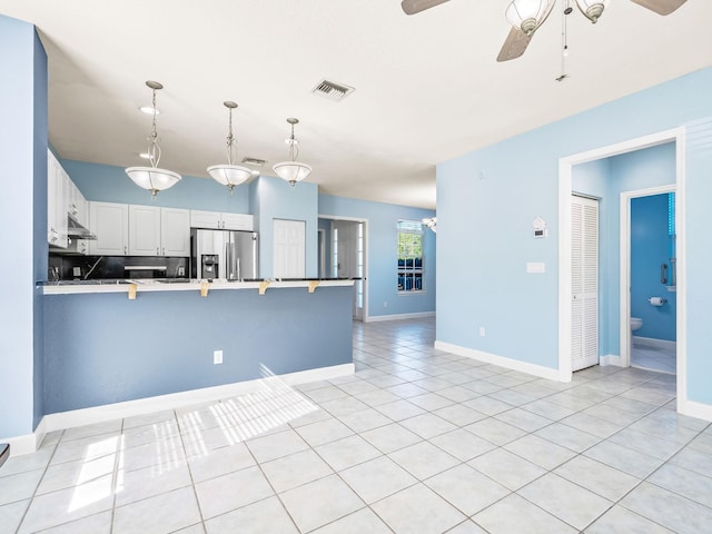 2123 Fernleigh Dr, Tallahassee, FL 32311 - kitchen featuring ceiling fan, a peninsula, stainless steel fridge, light tile patterned floors, and pendant lighting