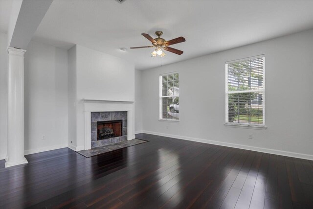 2123 Fernleigh Dr, Tallahassee, FL 32311 - unfurnished living room with ornate columns, baseboards, a tile fireplace, ceiling fan, and dark wood-style floors