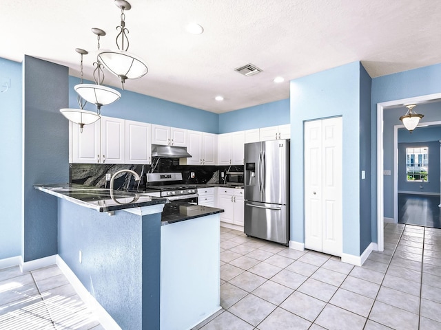 2123 Fernleigh Dr, Tallahassee, FL 32311 - kitchen featuring appliances with stainless steel finishes, under cabinet range hood, dark countertops, a peninsula, and white cabinets