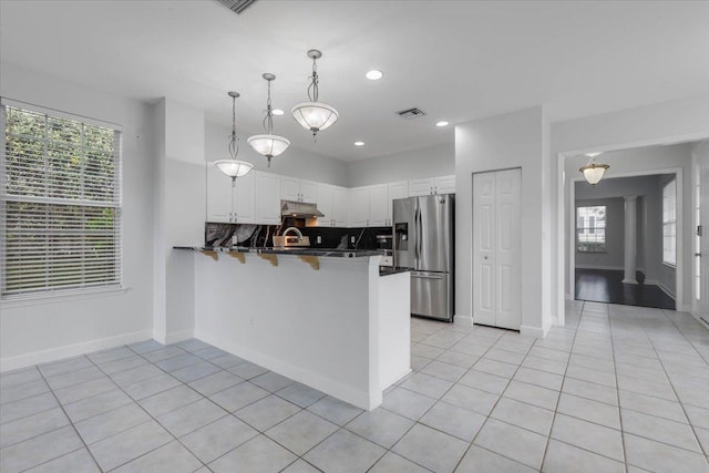 2123 Fernleigh Dr, Tallahassee, FL 32311 - kitchen with stainless steel refrigerator with ice dispenser, under cabinet range hood, a peninsula, white cabinetry, and light tile patterned flooring