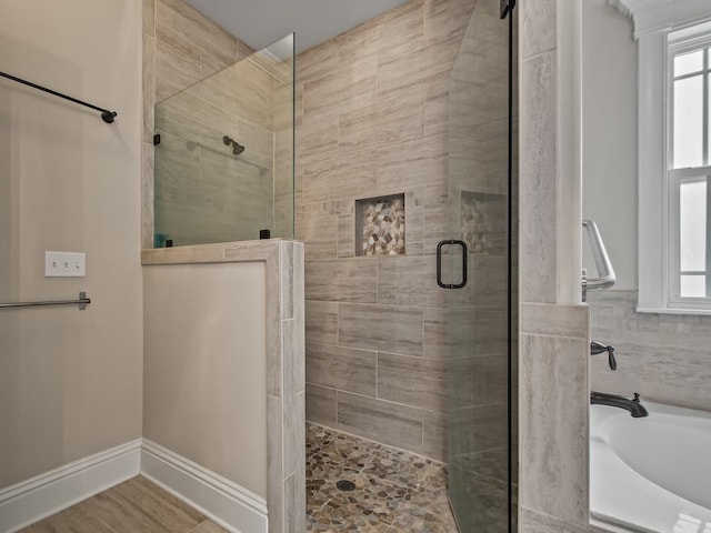 bathroom with hardwood / wood-style flooring and shower with separate bathtub