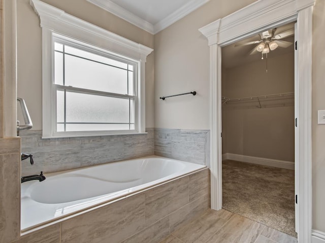 bathroom with ornamental molding, tiled bath, and ceiling fan