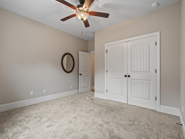 unfurnished bedroom featuring light carpet, ceiling fan, and a closet