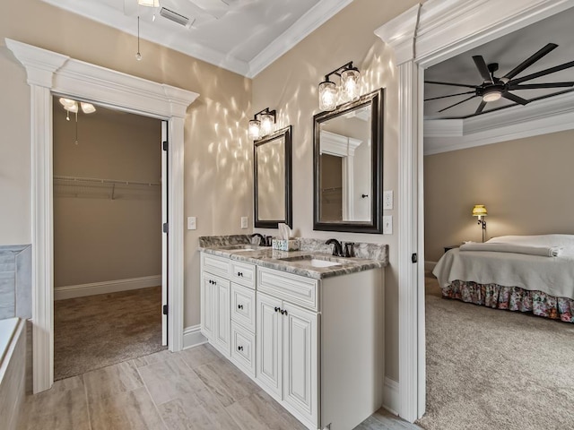 bathroom with crown molding, ceiling fan, and vanity