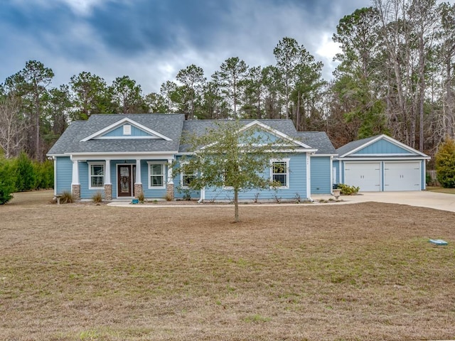 view of front of home featuring a porch, a garage, and a front yard