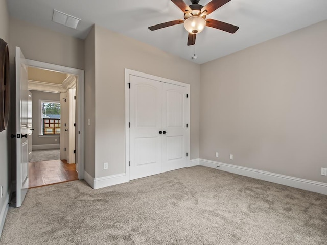 unfurnished bedroom with carpet flooring, ceiling fan, and a closet