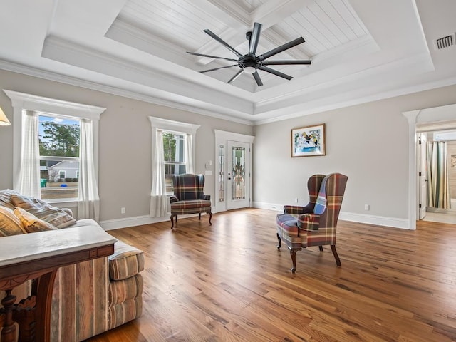 interior space featuring ornamental molding, wood-type flooring, and a tray ceiling