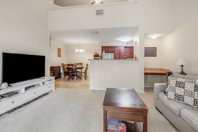 living room with visible vents, a chandelier, and light carpet