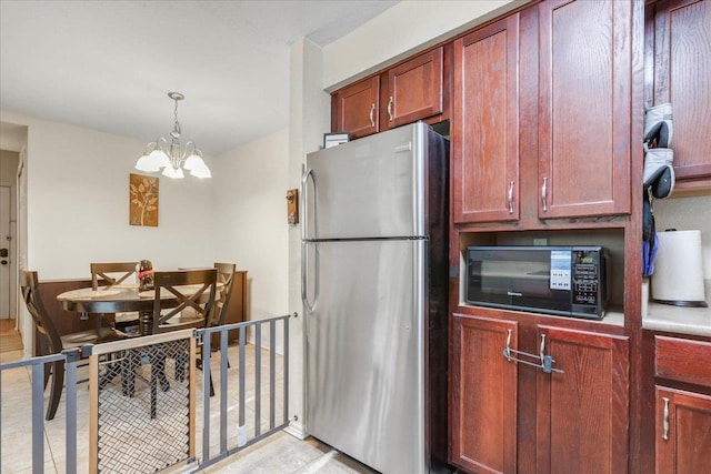kitchen featuring black microwave, an inviting chandelier, dark brown cabinets, and freestanding refrigerator