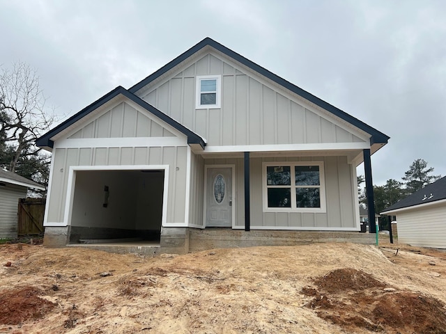 view of front of house featuring board and batten siding, covered porch, and a garage