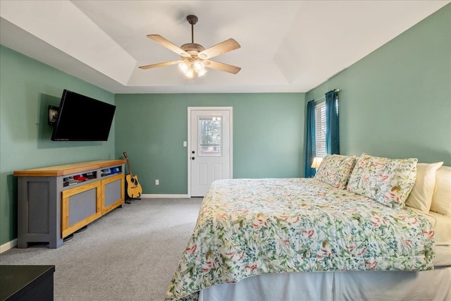 bedroom featuring ceiling fan, carpet floors, and a tray ceiling