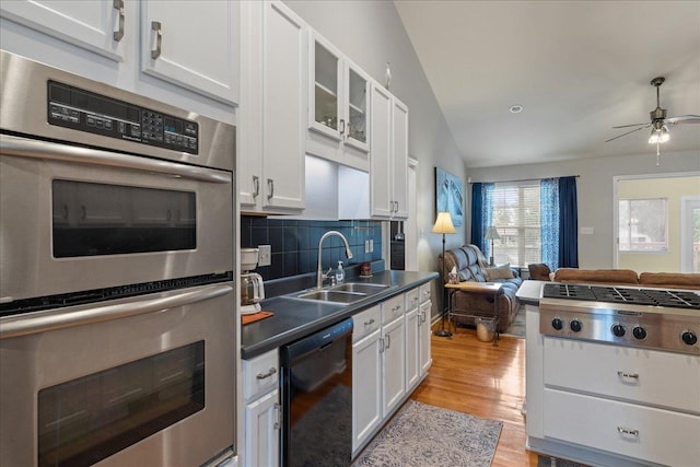 kitchen featuring lofted ceiling, sink, appliances with stainless steel finishes, light hardwood / wood-style floors, and white cabinetry