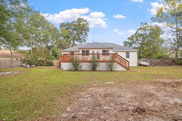 rear view of house with a lawn and a wooden deck