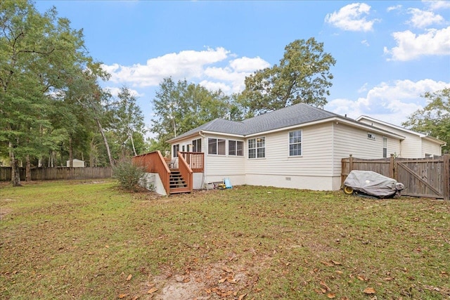 back of property featuring a wooden deck and a yard